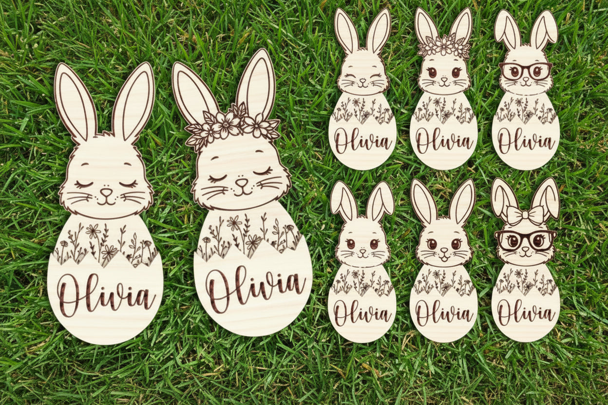 Set of bunny face cutouts with floral designs and the name  on a wooden background.